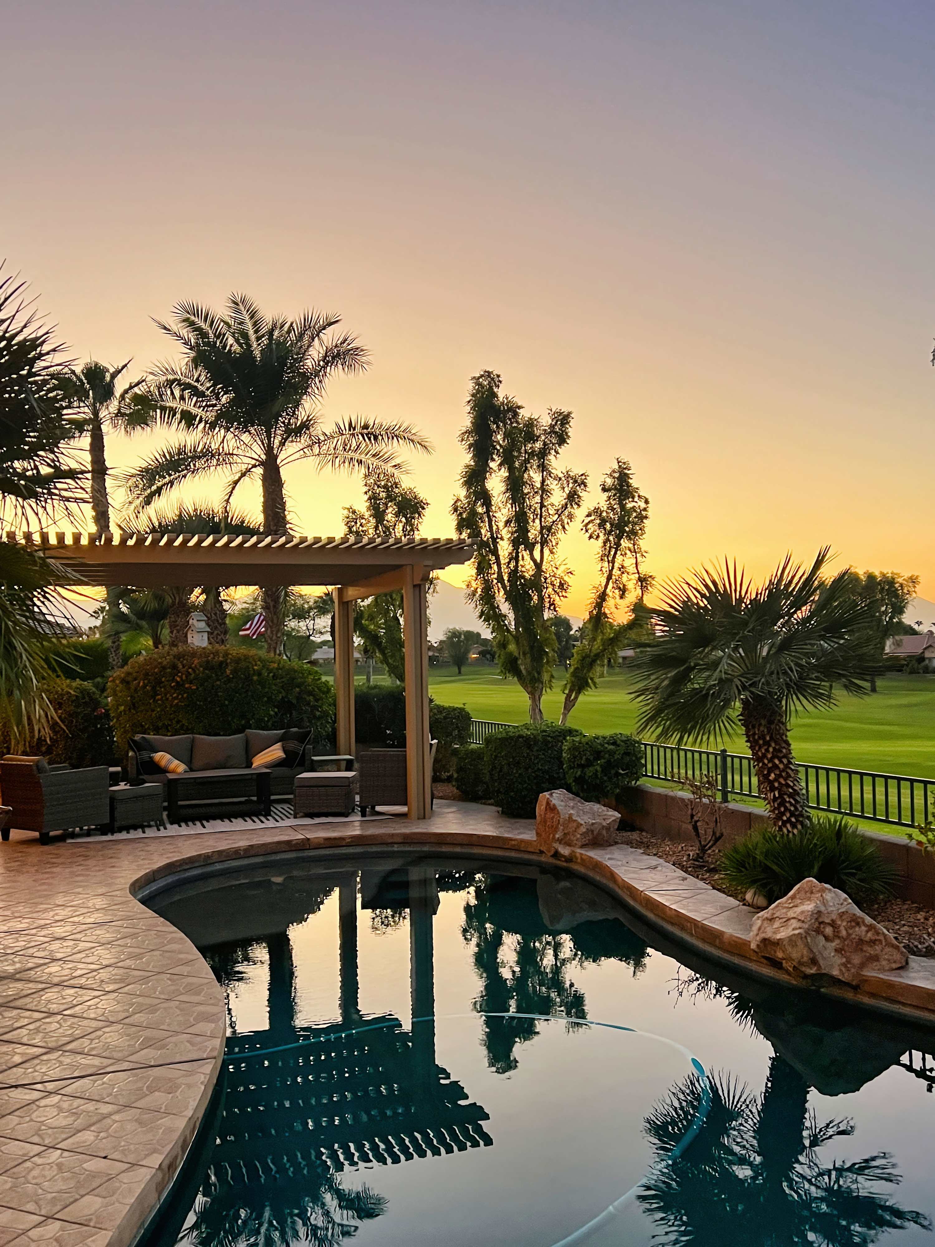 Outdoor pergola lounge at sunset overlooking golf course